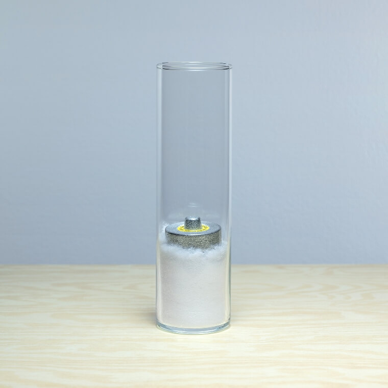 A weight is placed inside the glass container, and the OCTAIR™ is in a compressed state